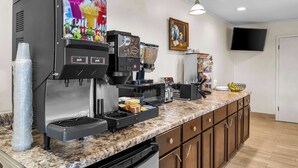 A self-service coffee station with a digital menu, a microwave, and a small refrigerator. - Americas Best Value Inn Belleville (Belleville)