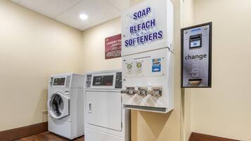 A laundry facility with washers, dryers, and a coin-operated soap and bleach softener dispenser.