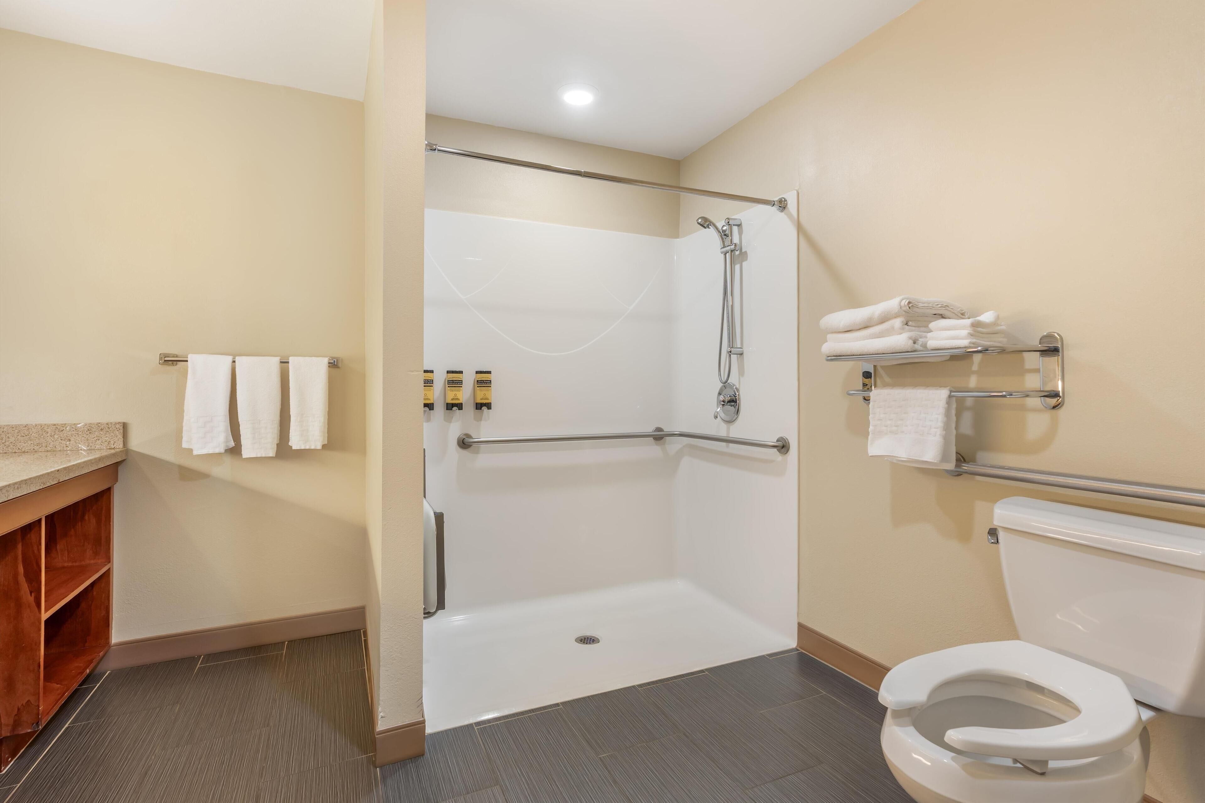 A bathroom with a shower, toilet, and sink.