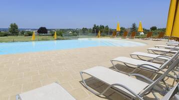 Una piscina al aire libre, tumbonas
