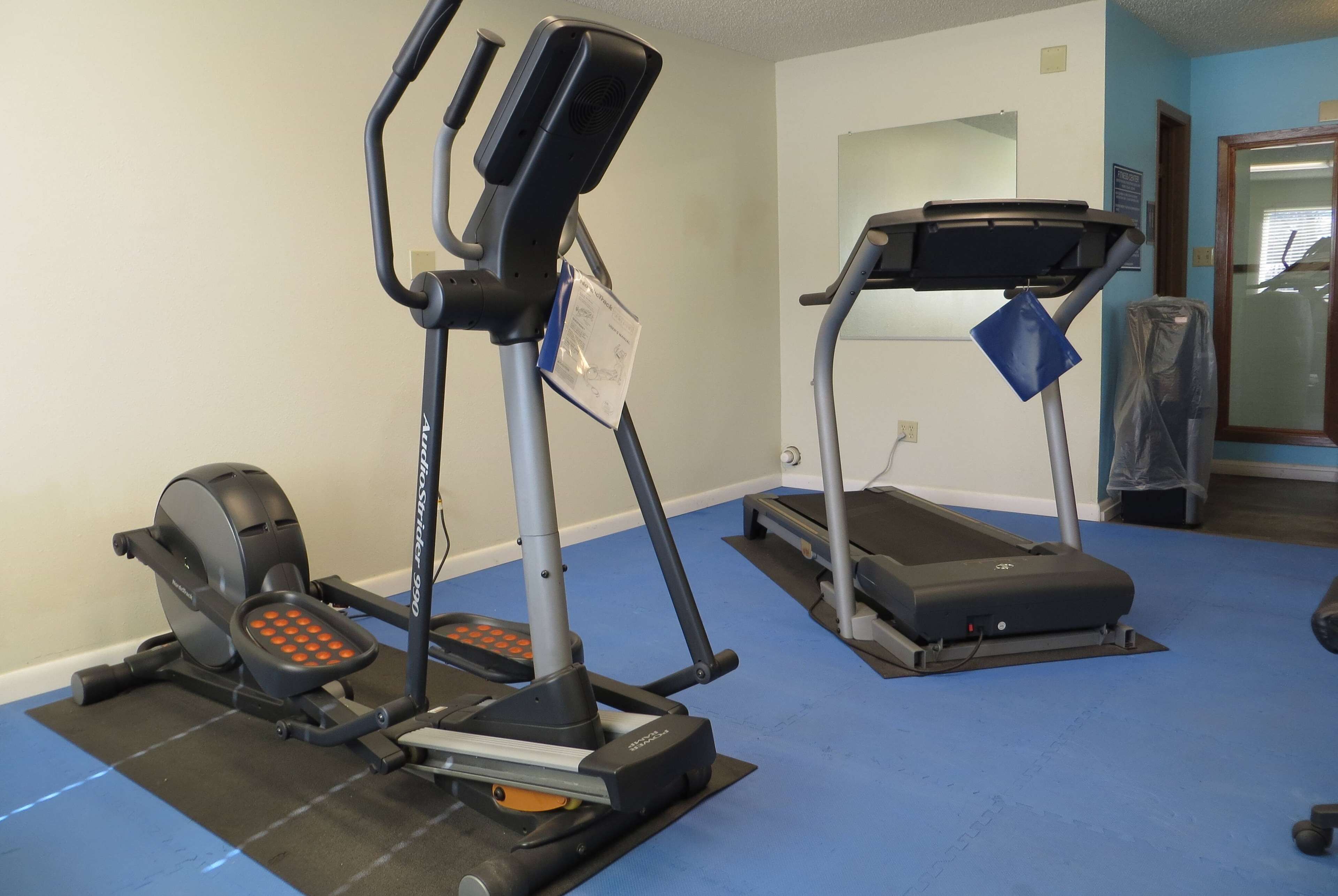 Ein Fitnessraum mit einem Ergometer, Crosstrainer und Laufband.