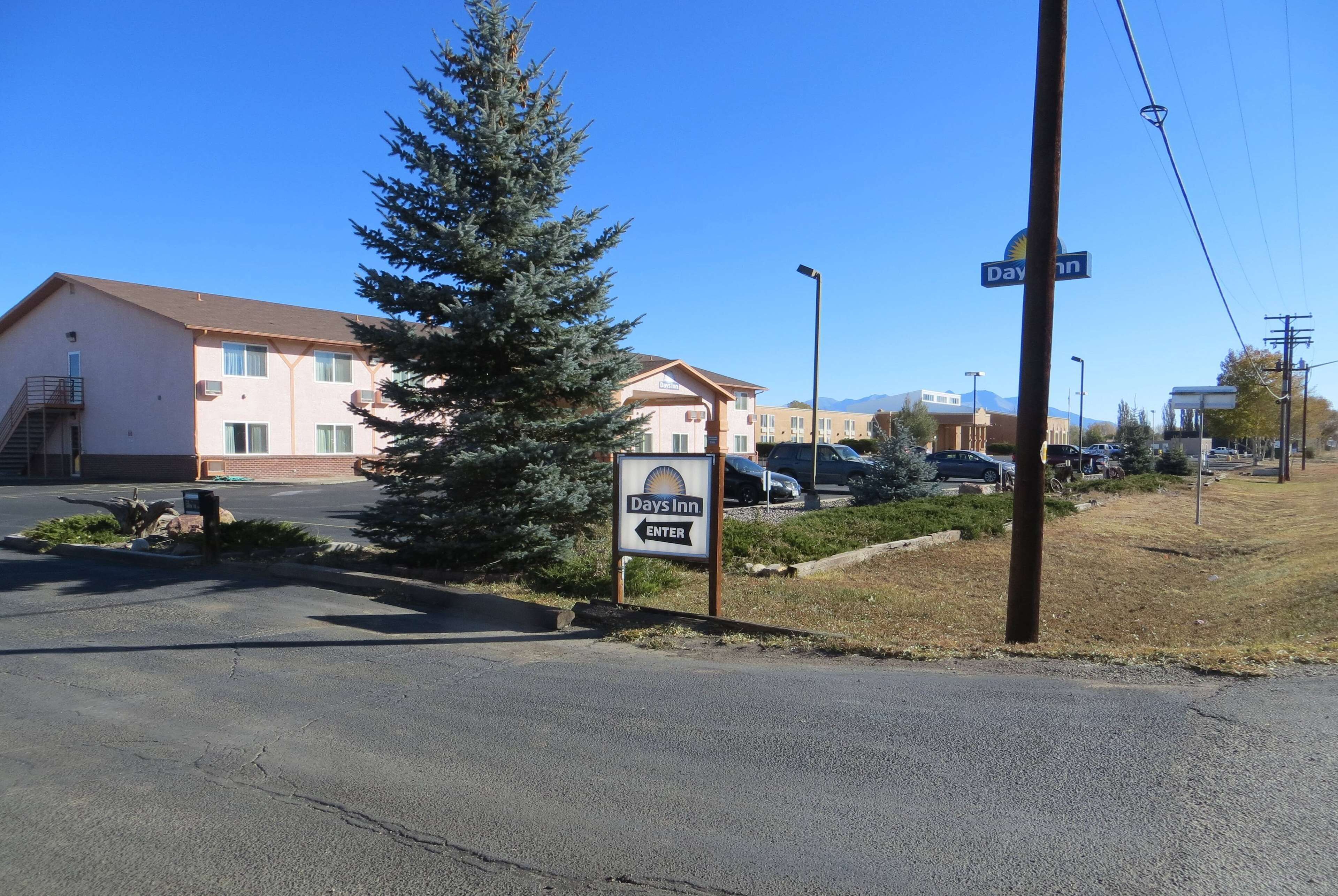 A Days Inn sign with a clear entrance, a parking lot, and a building with a flat roof and multiple windows.