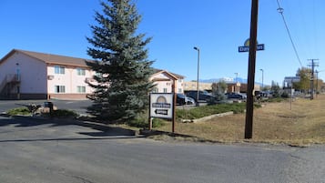 A Days Inn sign with a clear entrance, a parking lot, and a building with a flat roof and multiple windows.
