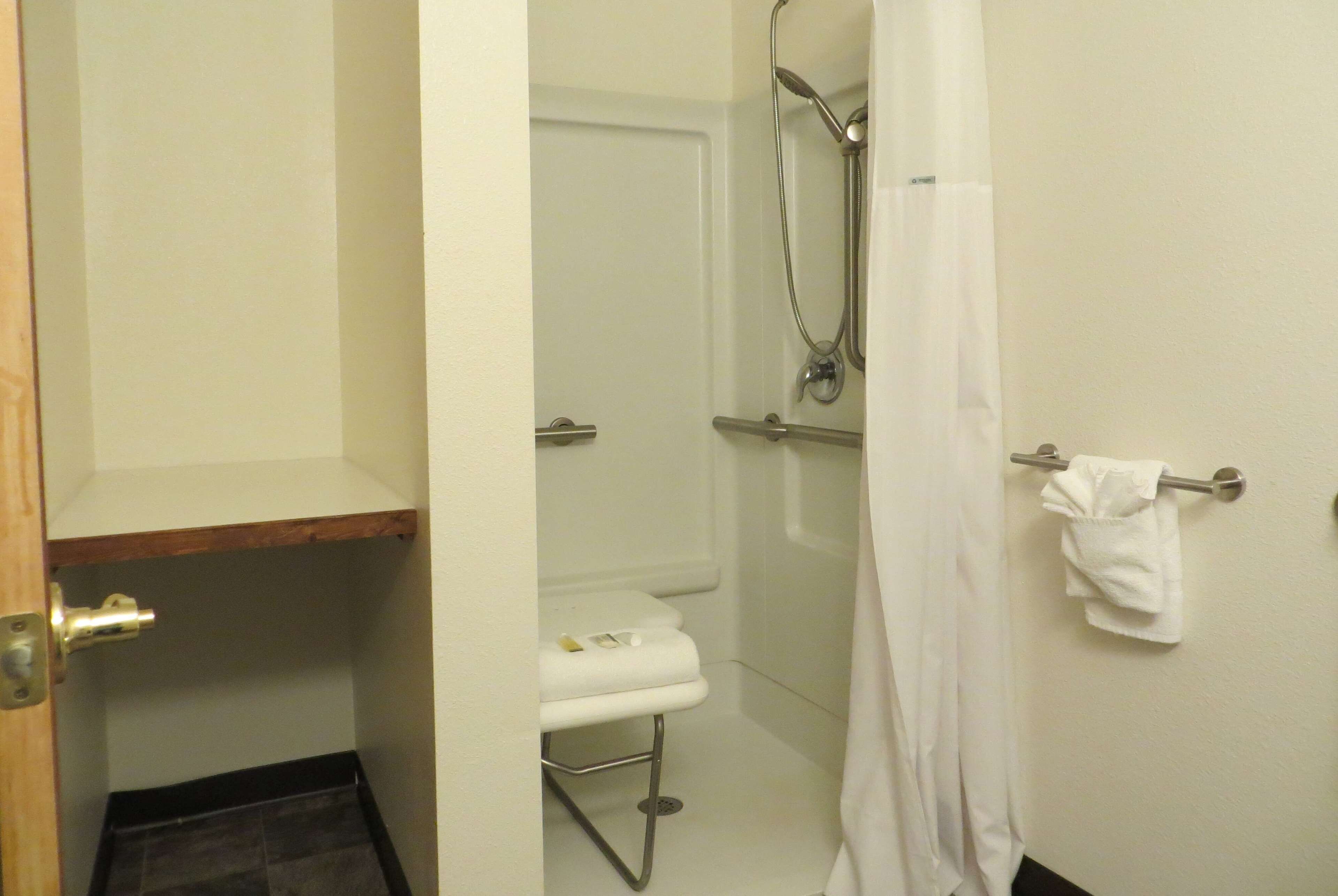 Un bagno con il water, doccia e portasciugamani.