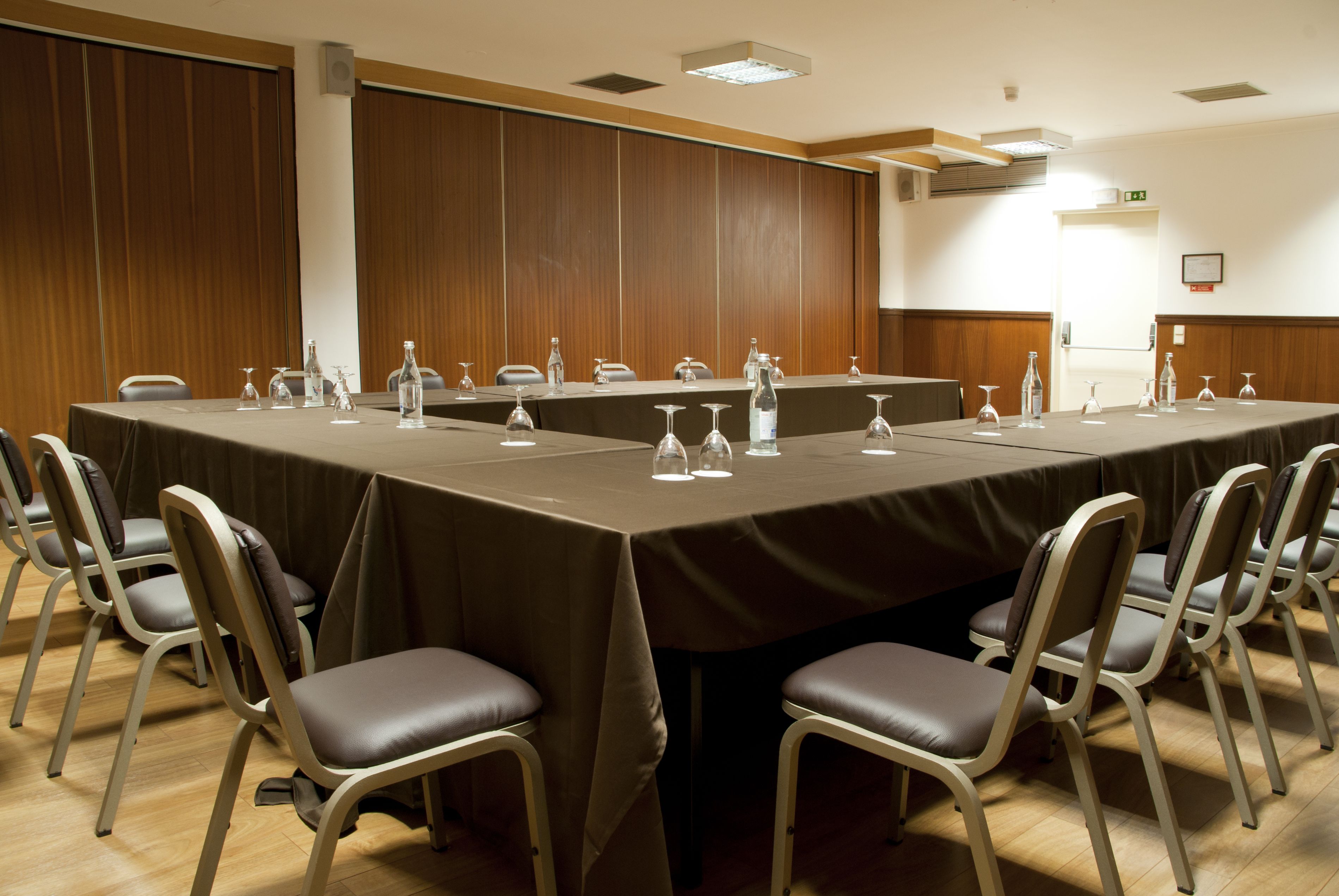 A conference room with a long table, chairs, and water bottles.
