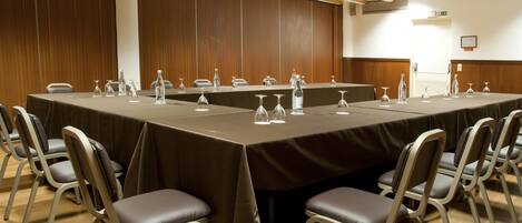 A conference room with a long table, chairs, and water bottles.