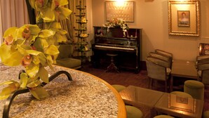 Una habitación con una mesa redonda, un piano y sillas.