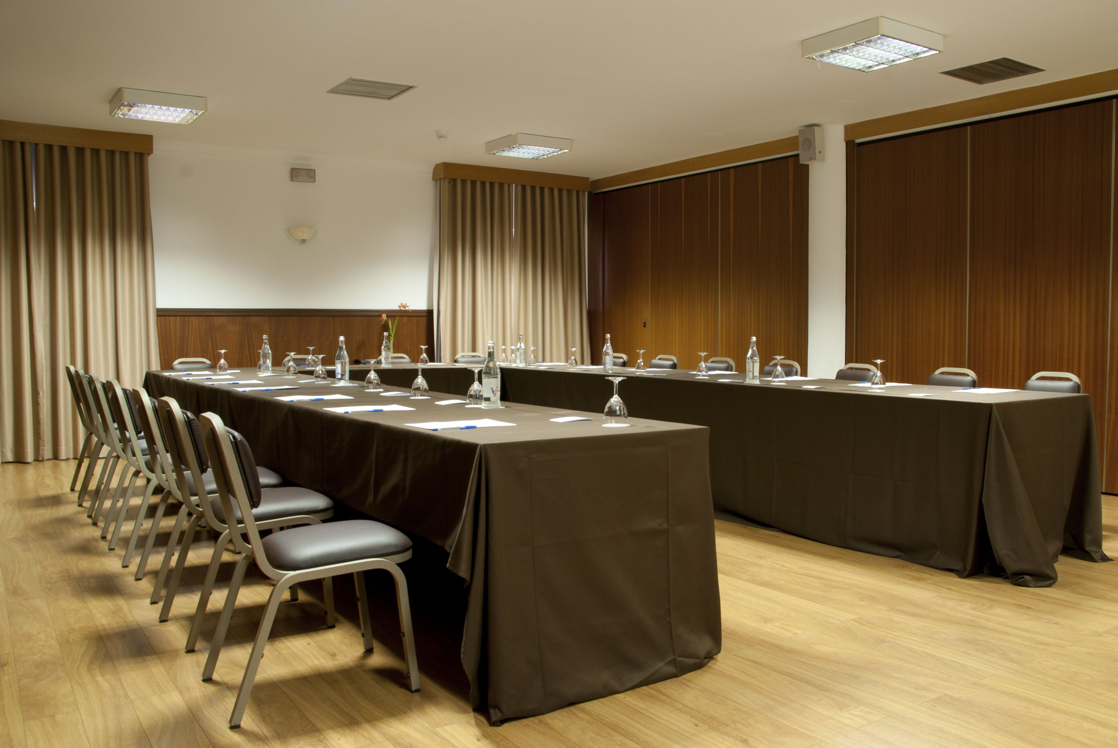 Ein Konferenzraum mit einem langen Tisch, Stühlen und Wasserflaschen.