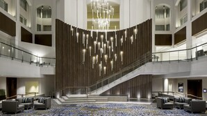 A spacious lobby with a central staircase, multiple floors, and a patterned carpet. - Grand Hyatt Washington (Washington)