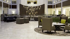 A spacious lobby with a high ceiling, modern lighting, and a central seating area with sofas and armchairs. - Grand Hyatt Washington (Washington)