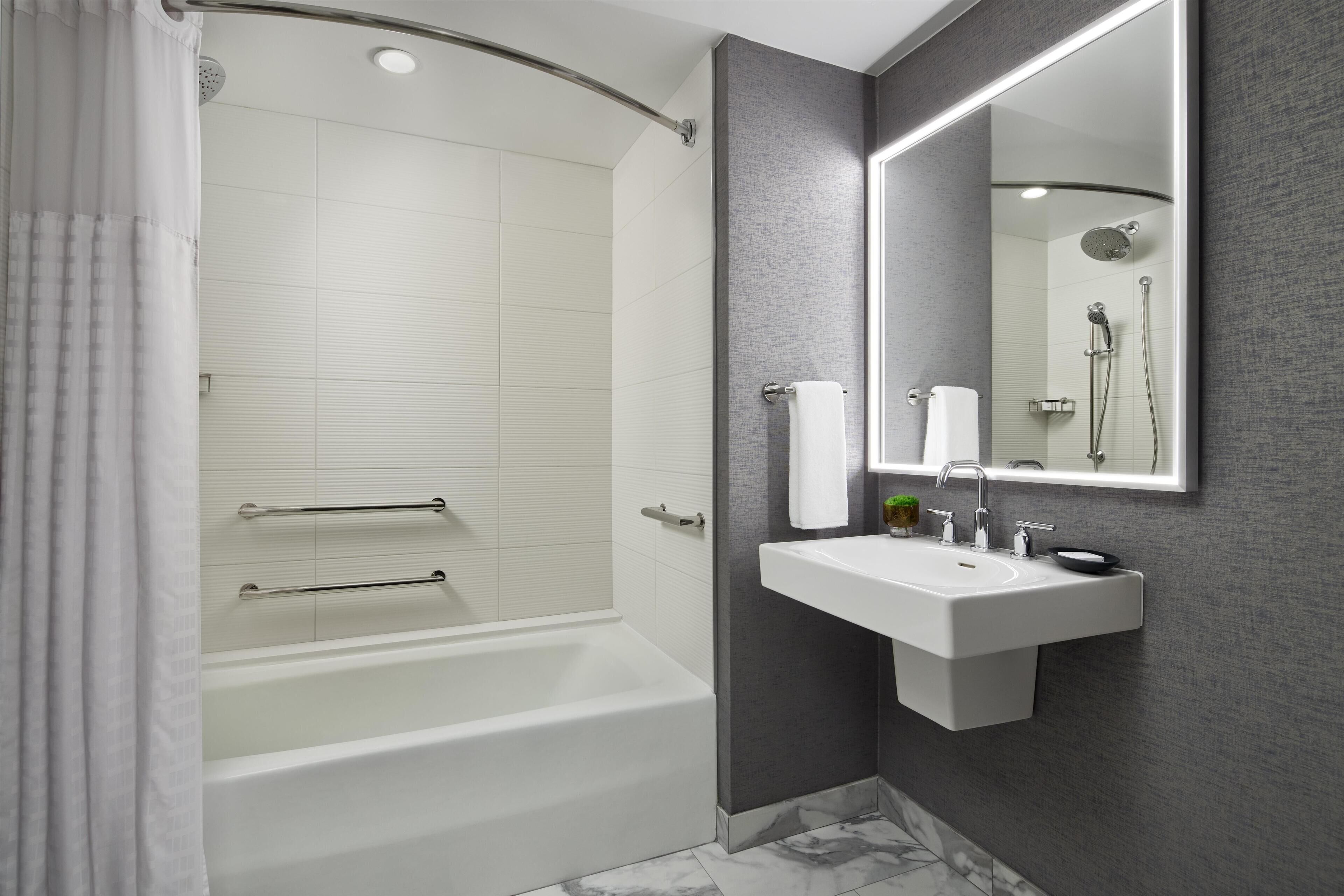 A modern bathroom with a bathtub, a sink, and a shower.