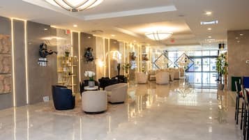 A modern lobby with a marble floor, seating area, and a reception desk.