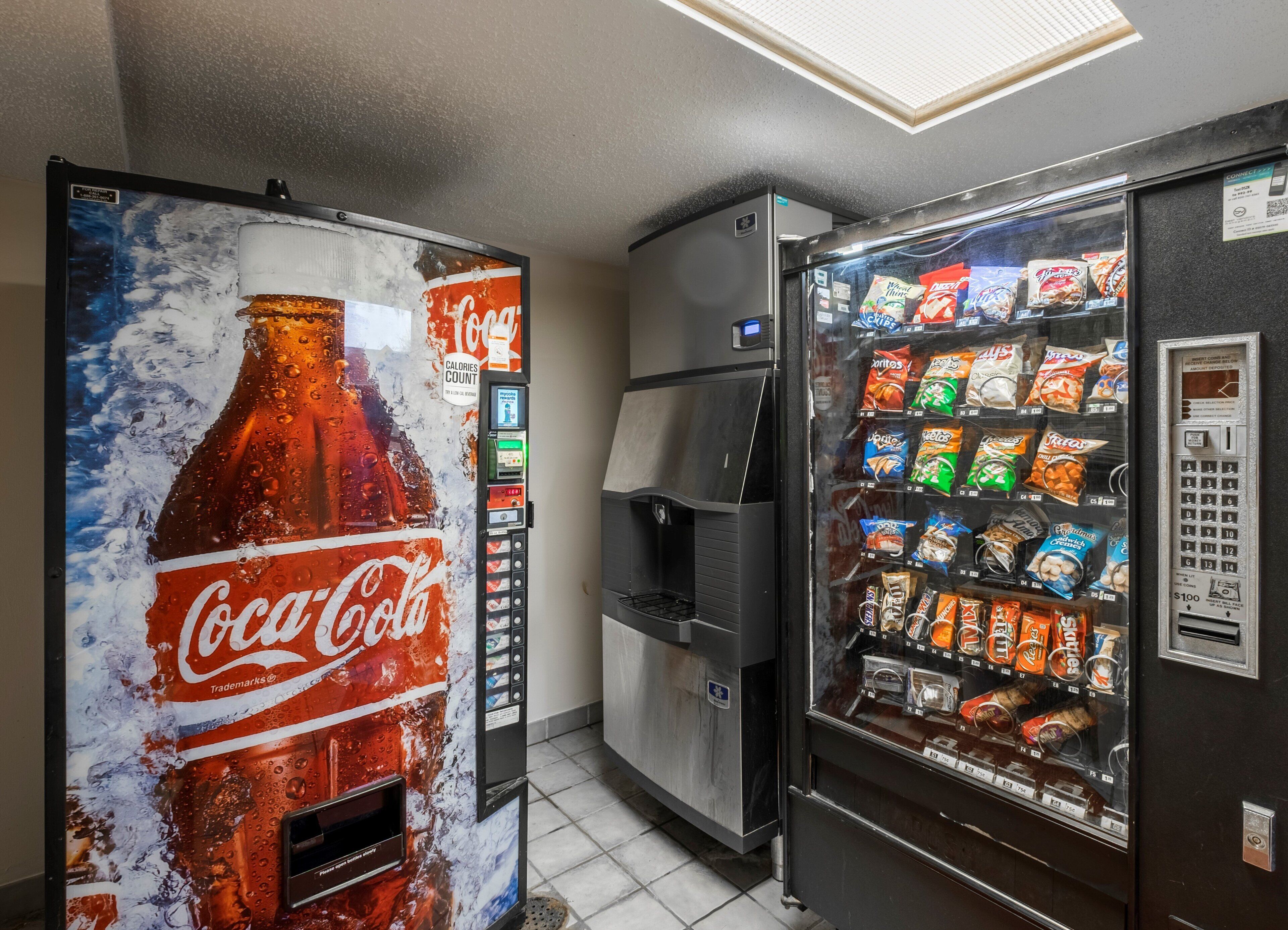 Un distributeur automatique arborant une publicité pour Coca-Cola et un autre distributeur proposant divers en-cas.