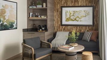 A modern living room with a sofa, armchair, coffee table, and a bookshelf.