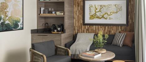 A modern living room with a sofa, armchair, coffee table, and a bookshelf.