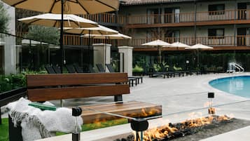 Alberca al aire libre, sombrillas en la alberca y camastros