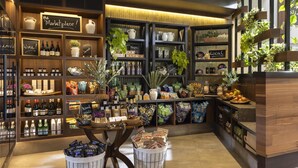 A well-organized store with shelves of wine, fresh produce, and various packaged goods.