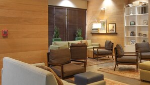 Una sala de estar moderna con paneles de madera, chimenea, televisor y estantería.