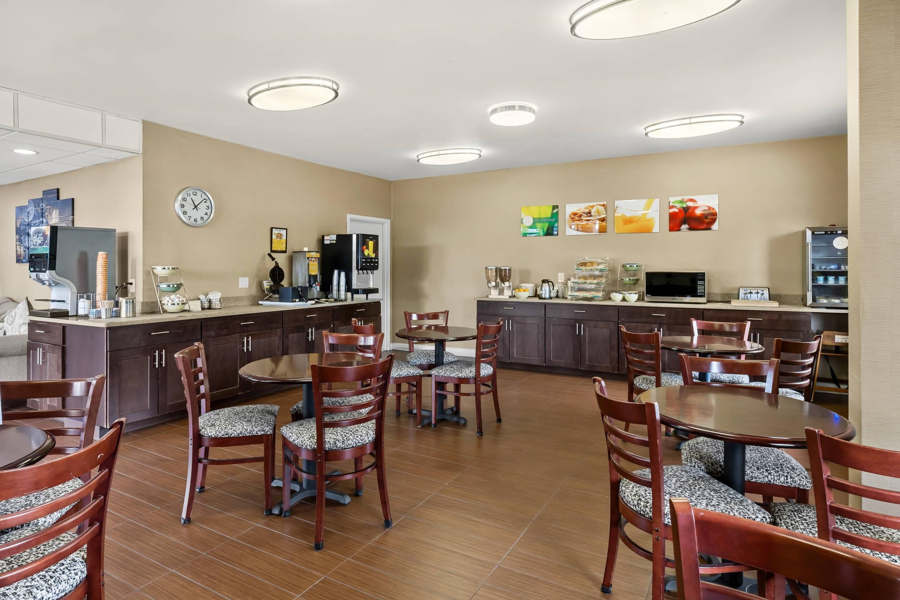 A hotel kitchen with a coffee machine, a clock, and a refrigerator.