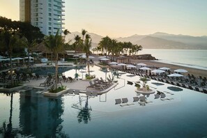 Una piscina techada, una piscina al aire libre, sombrillas