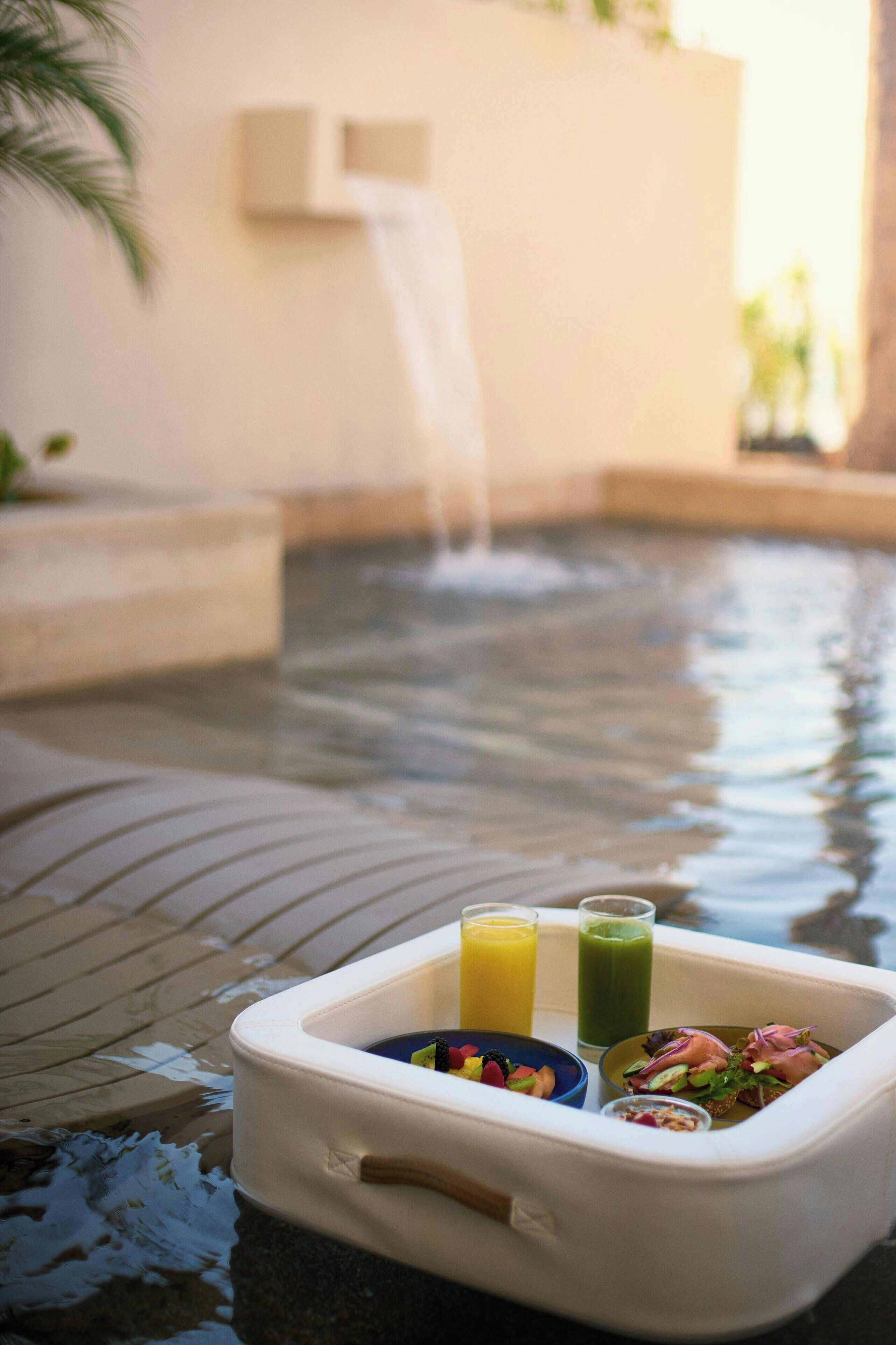 Une glacière portative contenant des boissons et de la nourriture, placée au bord de la piscine.