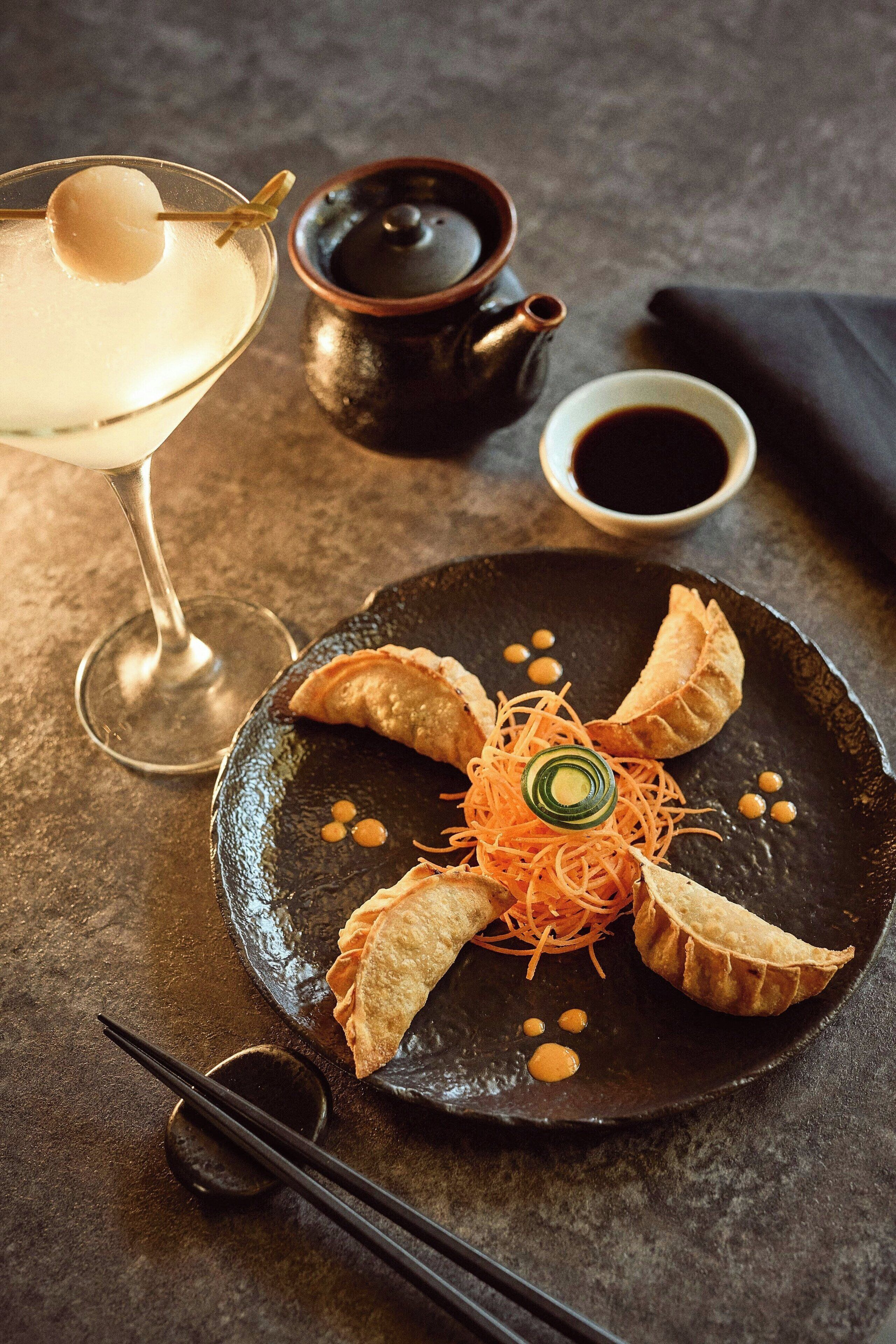 A plate of food with a drink and a teapot.