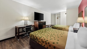Une chambre d’hôtel avec deux lits, un bureau, une chaise, une télévision et un miroir.