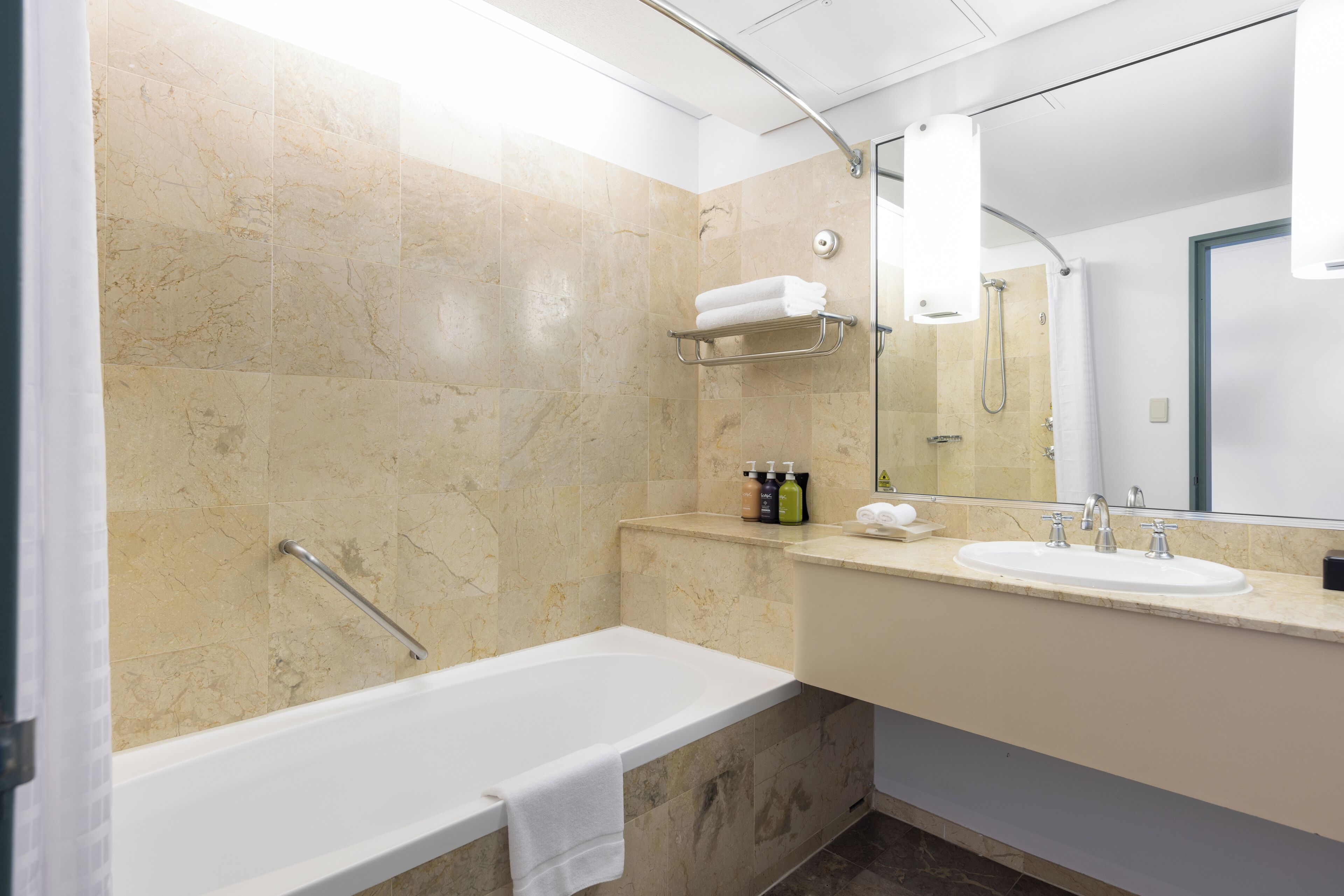 A modern bathroom with a bathtub, a sink, and a shower.