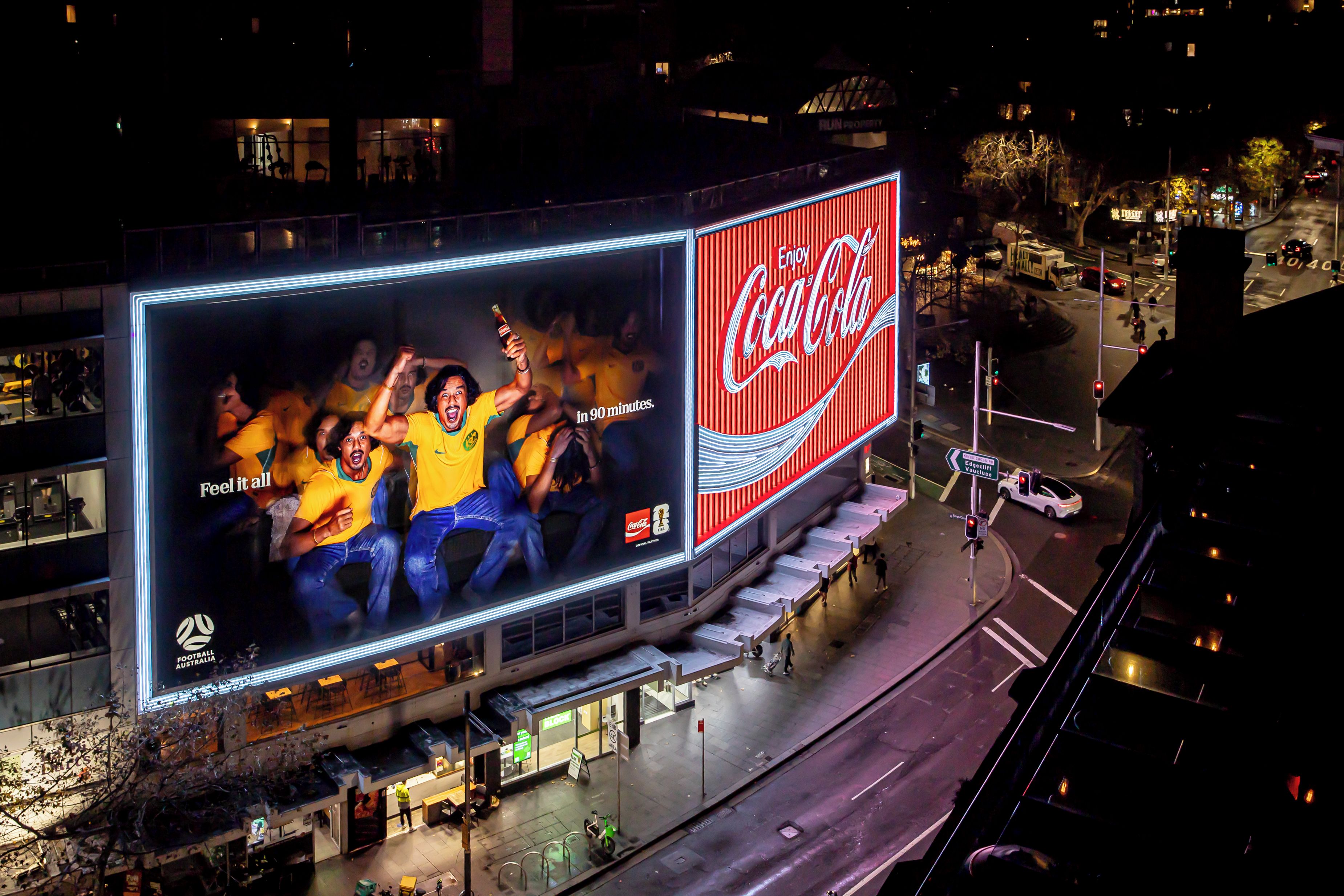 A large outdoor billboard with a Coca-Cola advertisement.