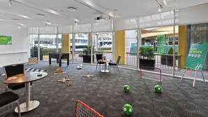 Ein Spielbereich für Kinder mit Tischen, Stühlen und Fußballtoren.