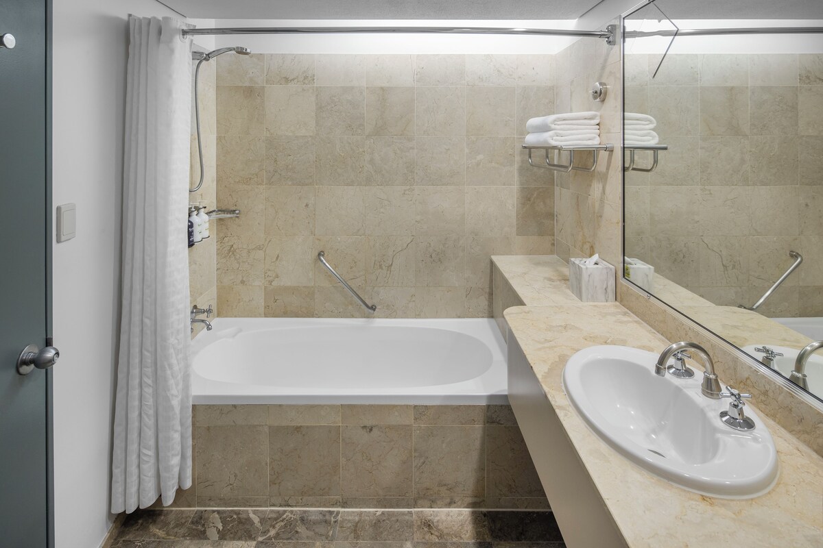 A modern bathroom with a bathtub, a sink, and a shower.