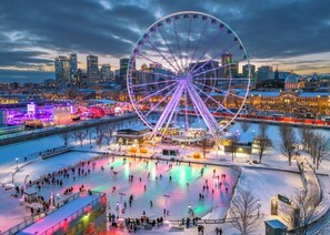 A large Ferris wheel with a cityscape in the background. - Holiday Inn Montreal Longueuil by IHG (Longueuil)