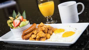 A breakfast plate with sausages, fried eggs, and hash browns.
