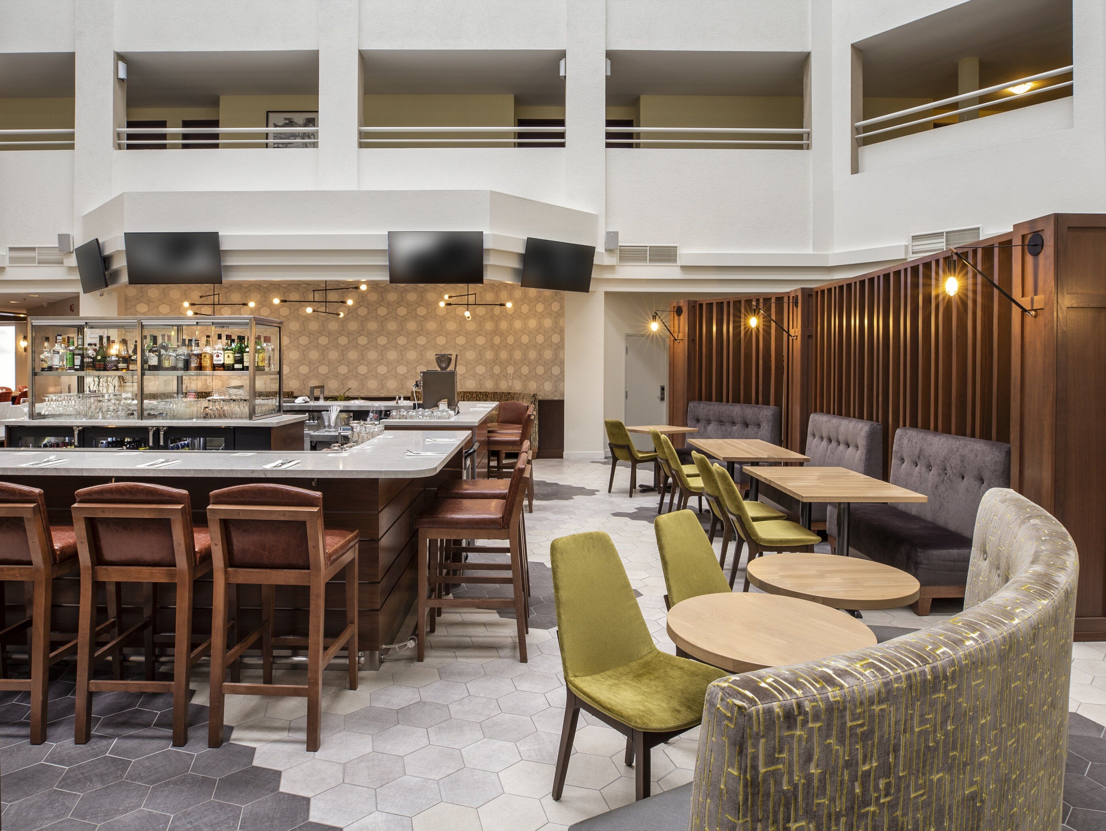 A modern bar area with a counter, seating, and a patterned wall.