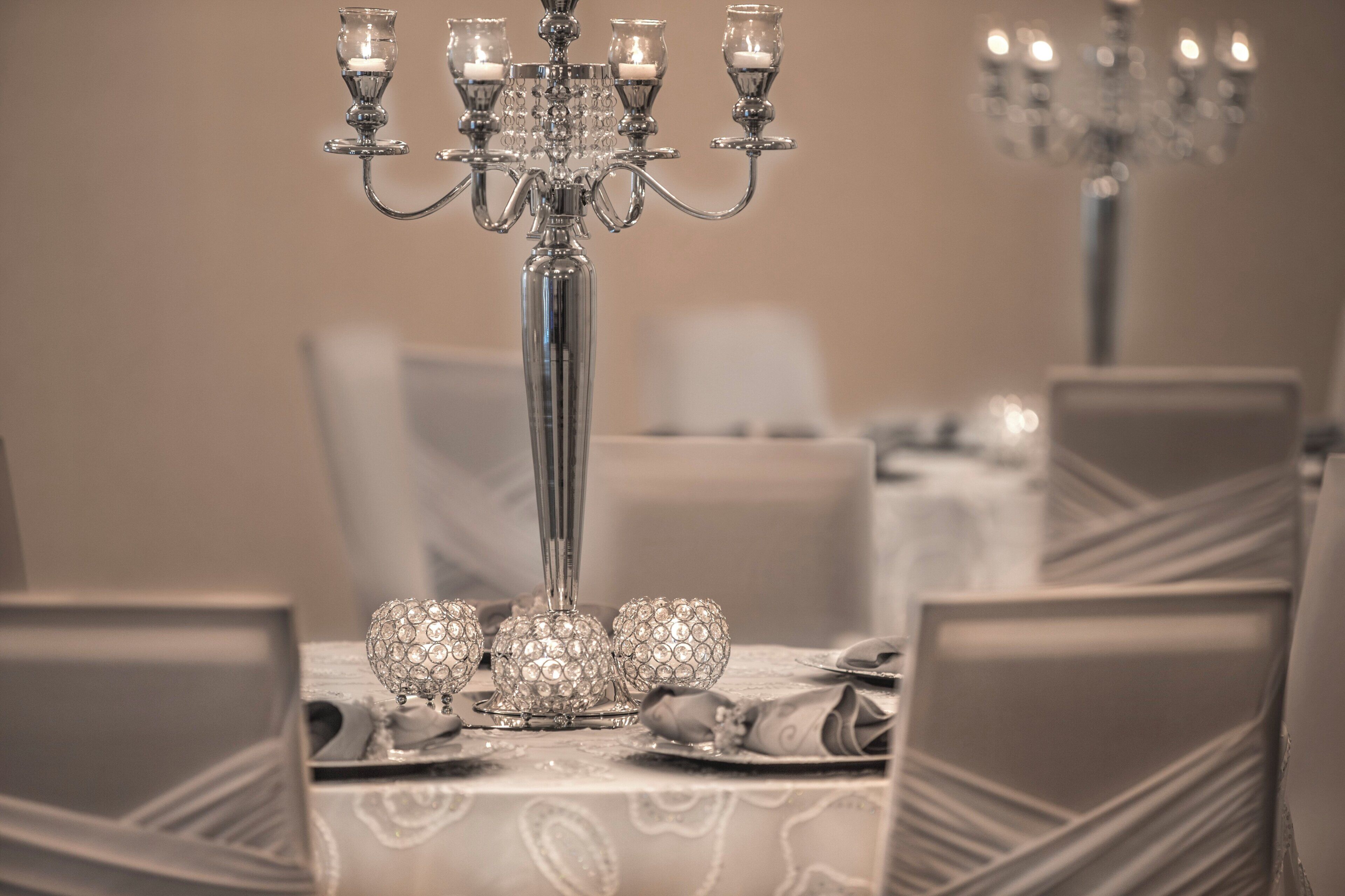 Una mesa de comedor decorada con cristalería de cristal y una araña.