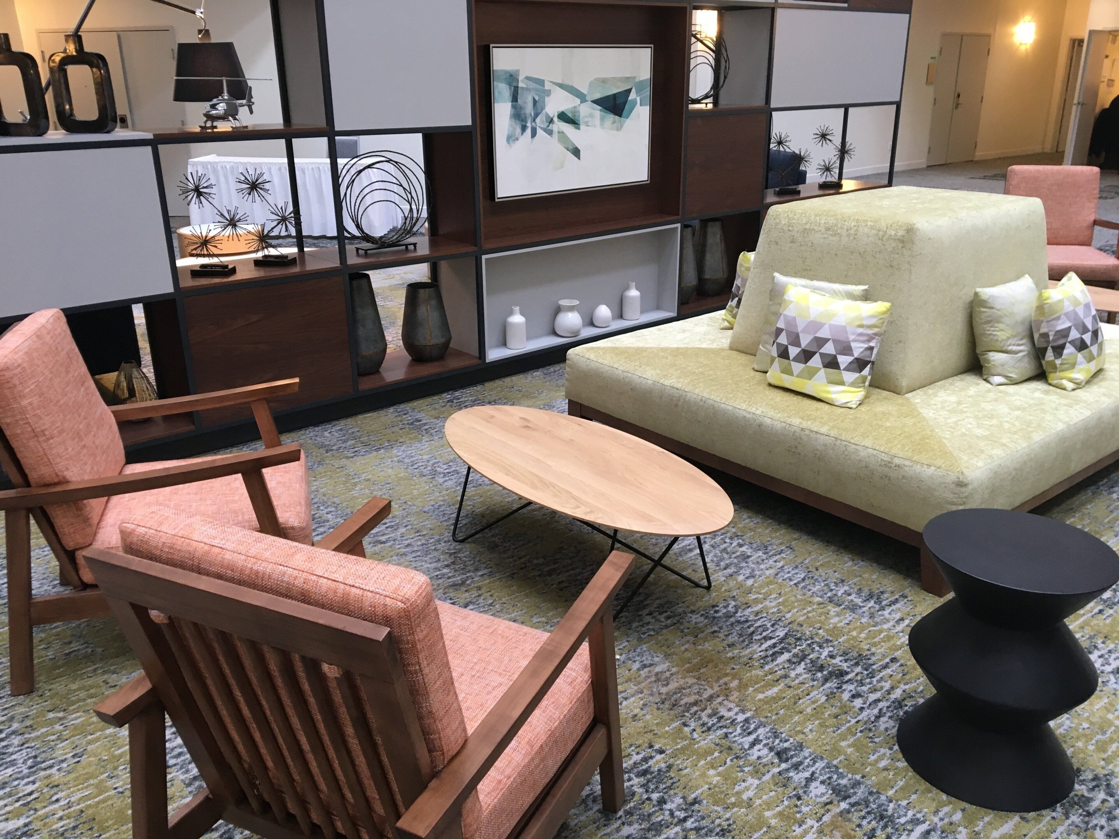 Una sala moderna con un sofá, dos sillones, una mesa baja y una mesita auxiliar negra.