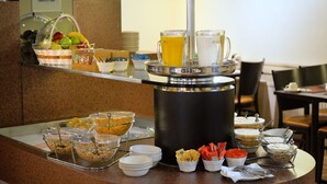 Una mesa de buffet con diversos alimentos y bebidas.