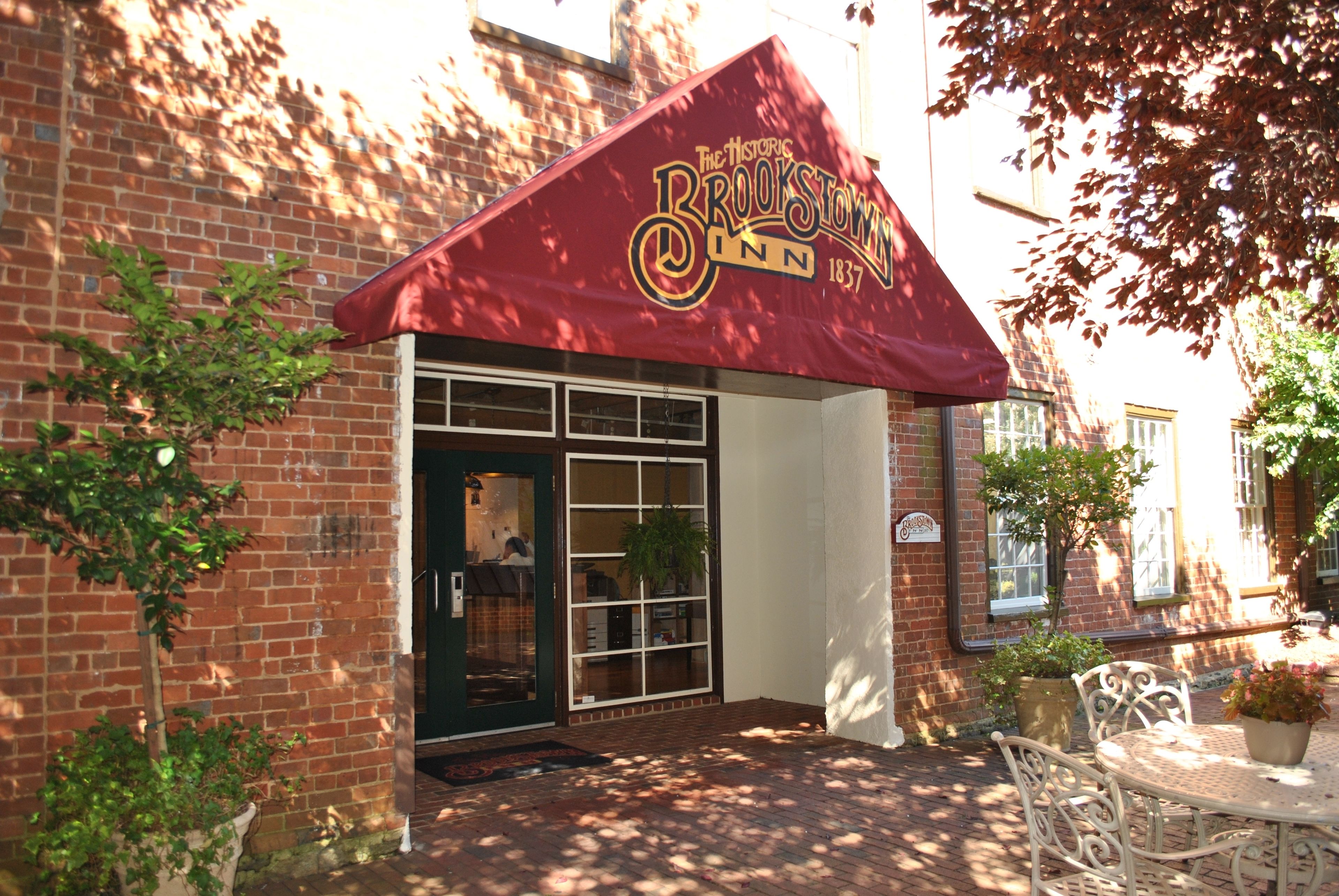 Un edificio de ladrillo con un toldo rojo que dice "The Historic Brooktown Inn 1837".