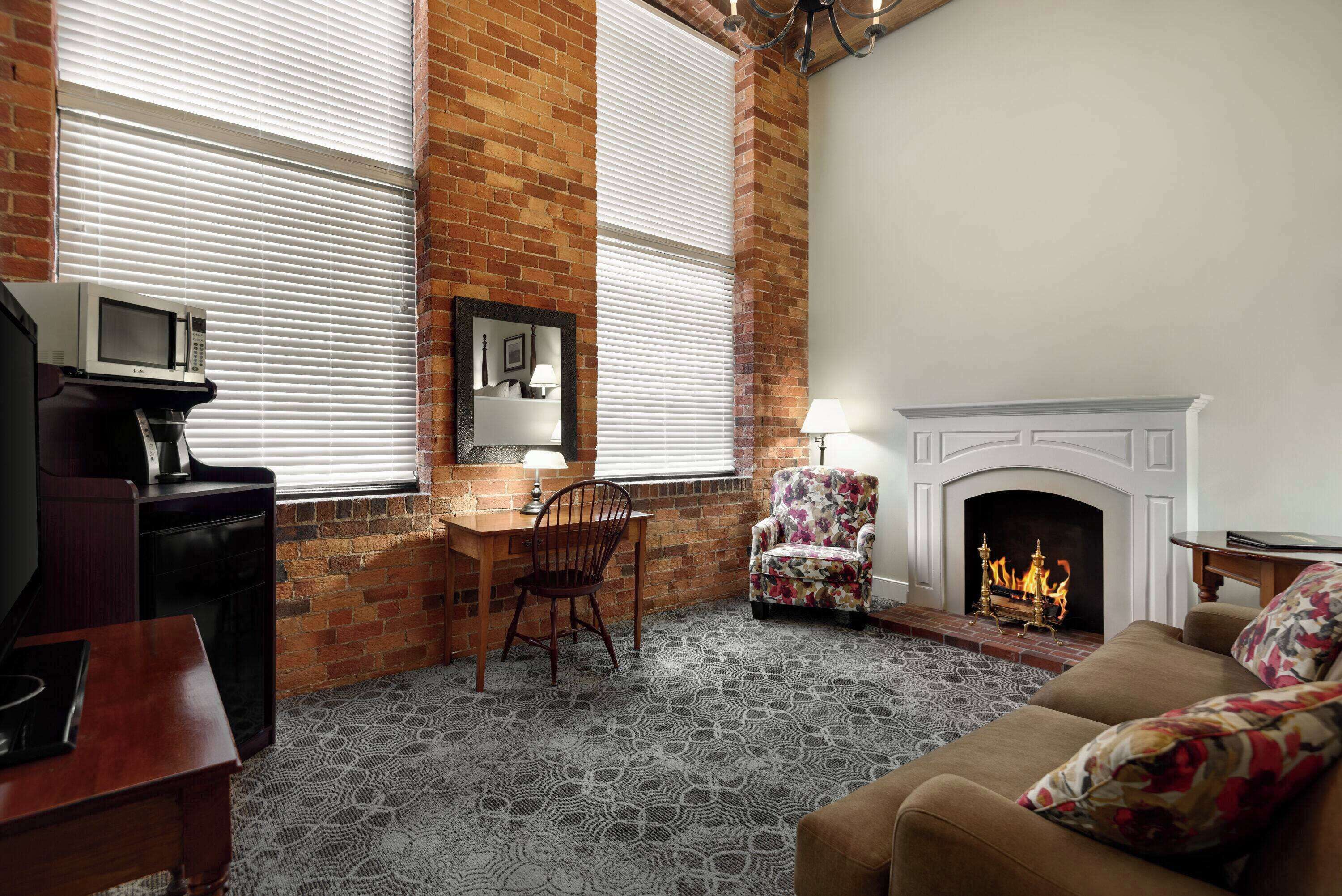 A cozy living room with a fireplace, a dining area with a table and chairs, and a television on a stand.