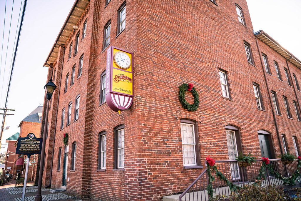 Un bâtiment en briques orné d’une horloge et d’une couronne de Noël.
