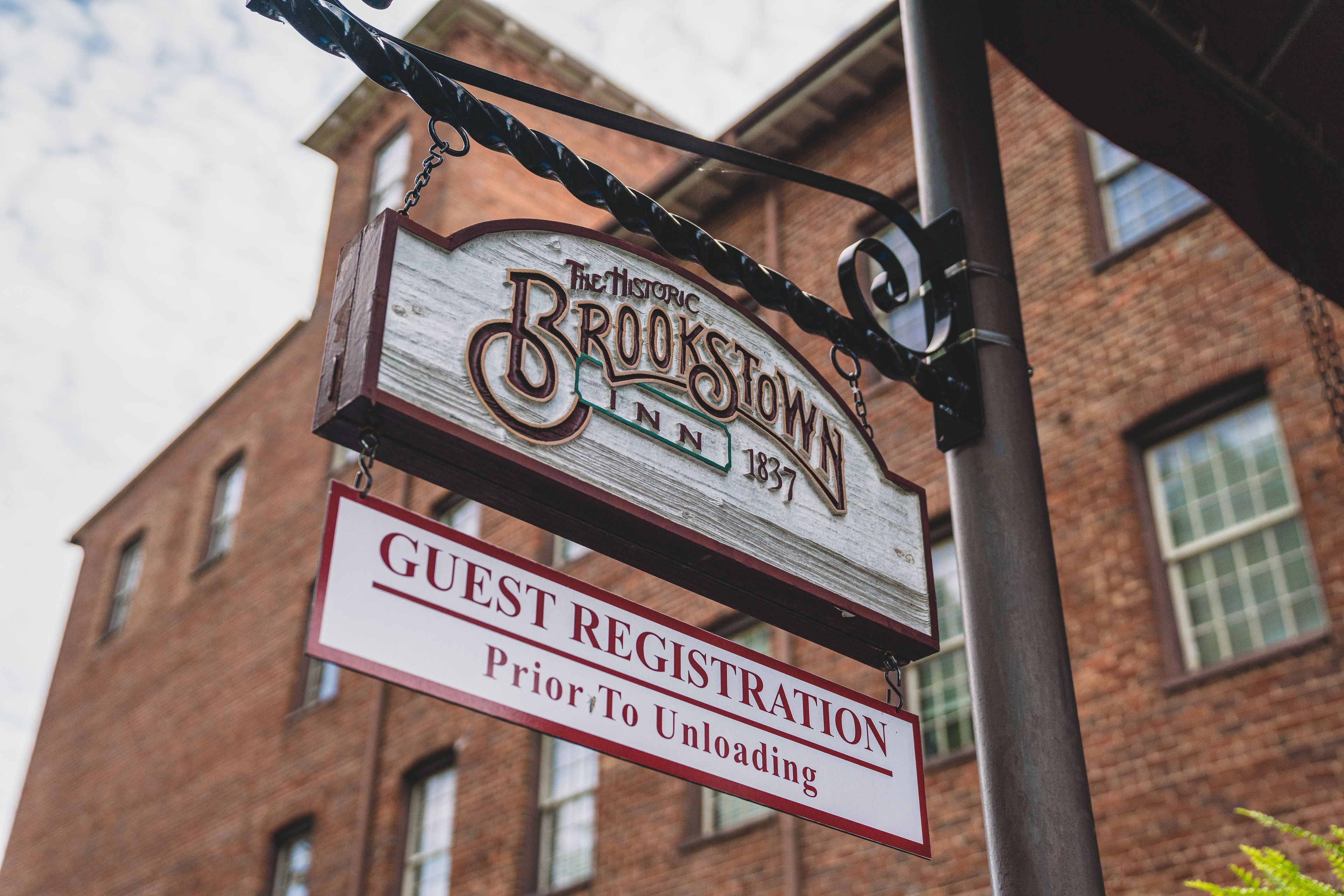 A sign for The Historic Brookstown Inn with a guest registration notice.
