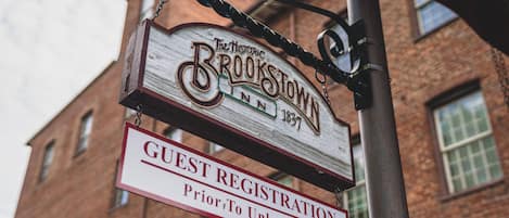Señal del Historic Brookstown Inn con aviso de registro de huéspedes.