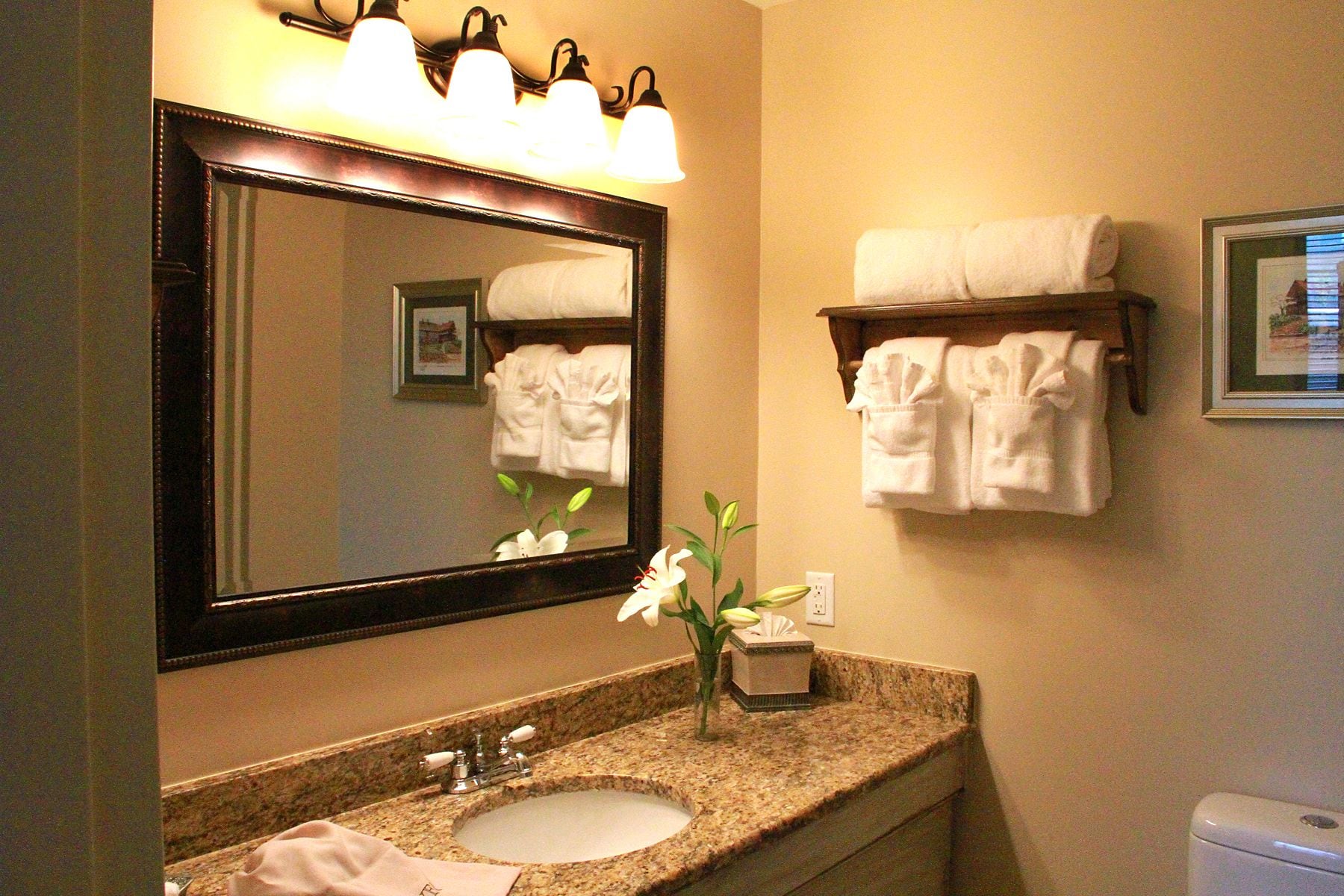 A bathroom with a large mirror, a sink, and a towel rack.