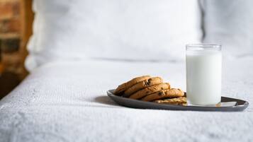 A plate of cookies and a glass of milk on a tray.