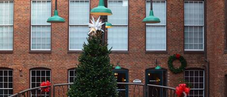 A brick building with a Christmas tree decorated with red bows and a white star.