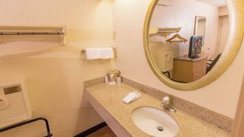 A bathroom with a sink, mirror, towel rack, and a small cabinet.