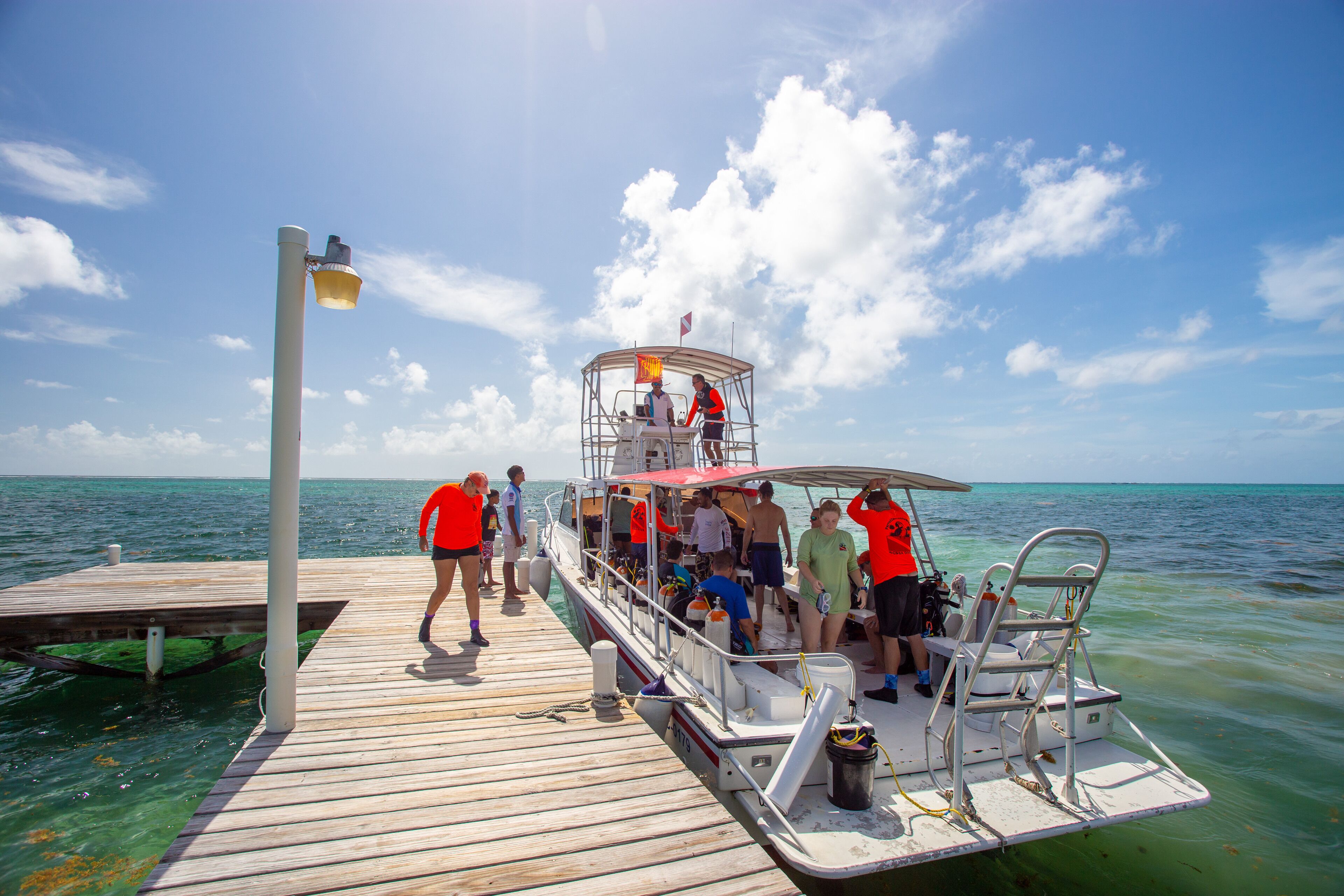 A boat docked at a pier with a clear view of the ocean.