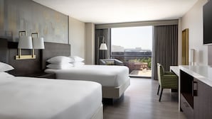 A hotel room with two beds, a desk, a chair, and a large window with a city view. - Dallas/Addison Marriott Quorum by the Galleria (Dallas)