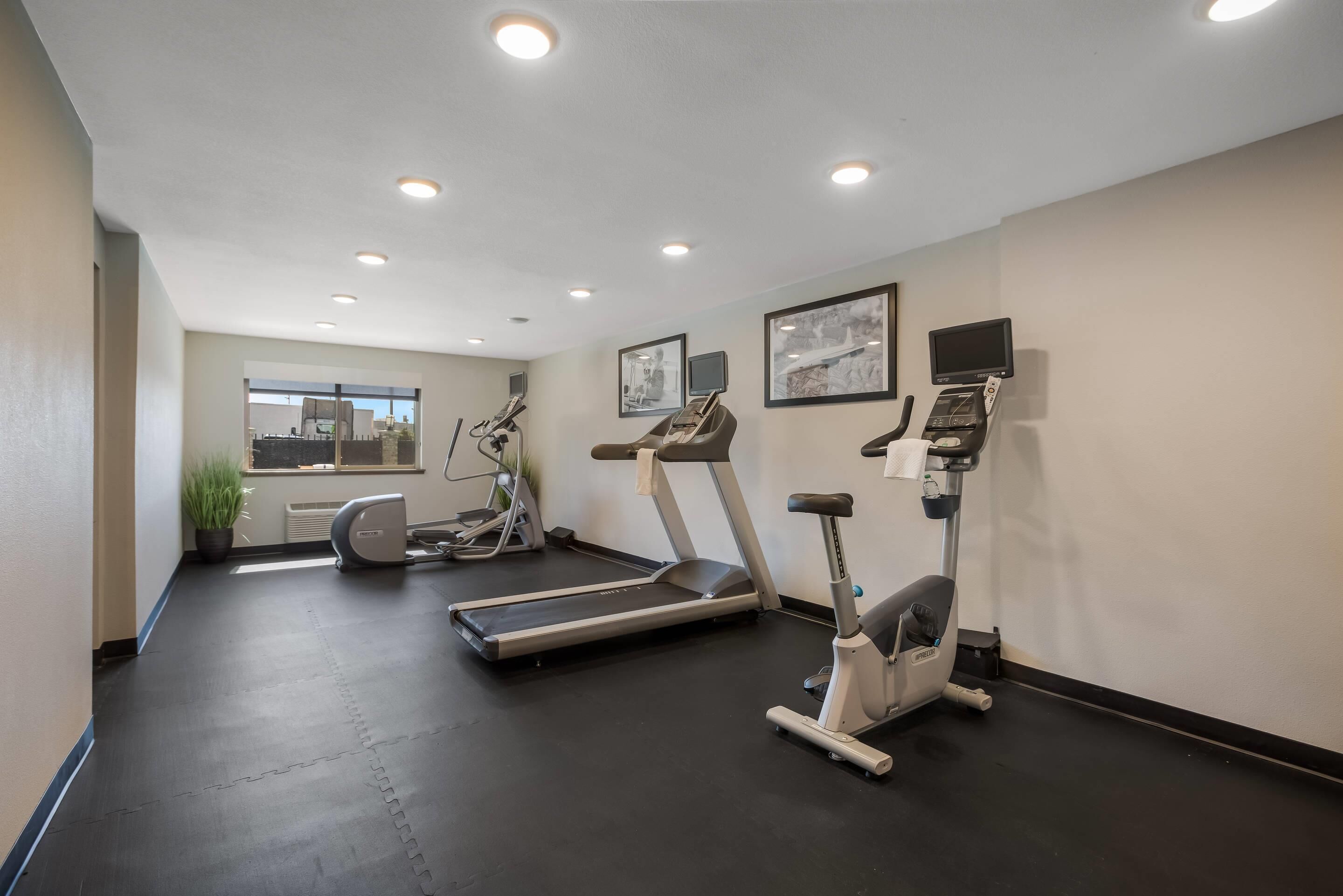 A gym with treadmills, elliptical machines, and stationary bikes.