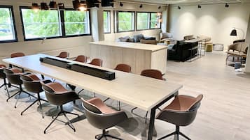 A modern meeting room with a long table, multiple chairs, and a central island.